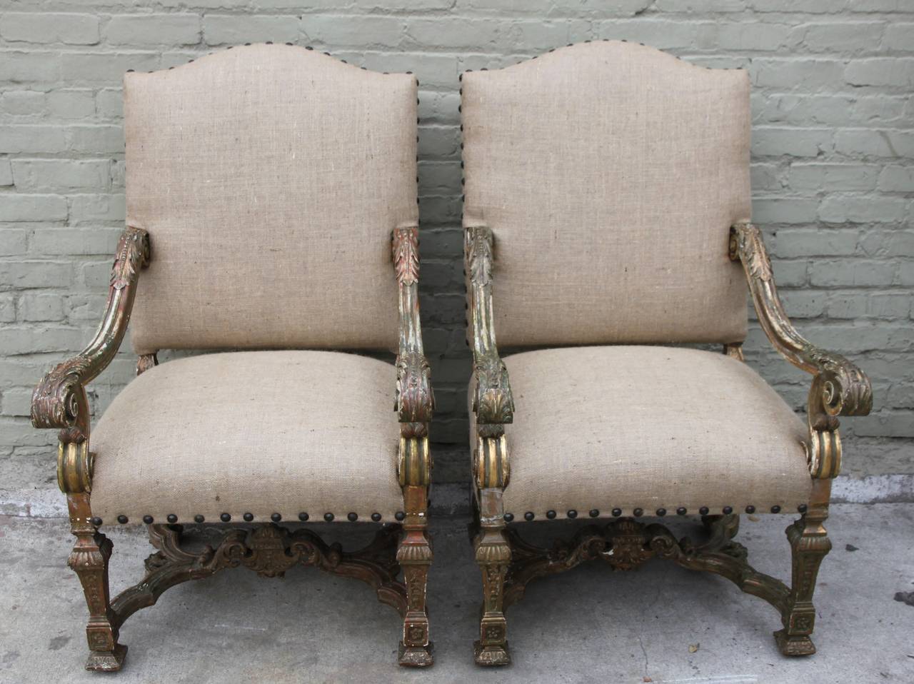 Pair of Italian painted and parcel-gilt armchairs newly upholstered in burlap textile with nailhead trim detail.