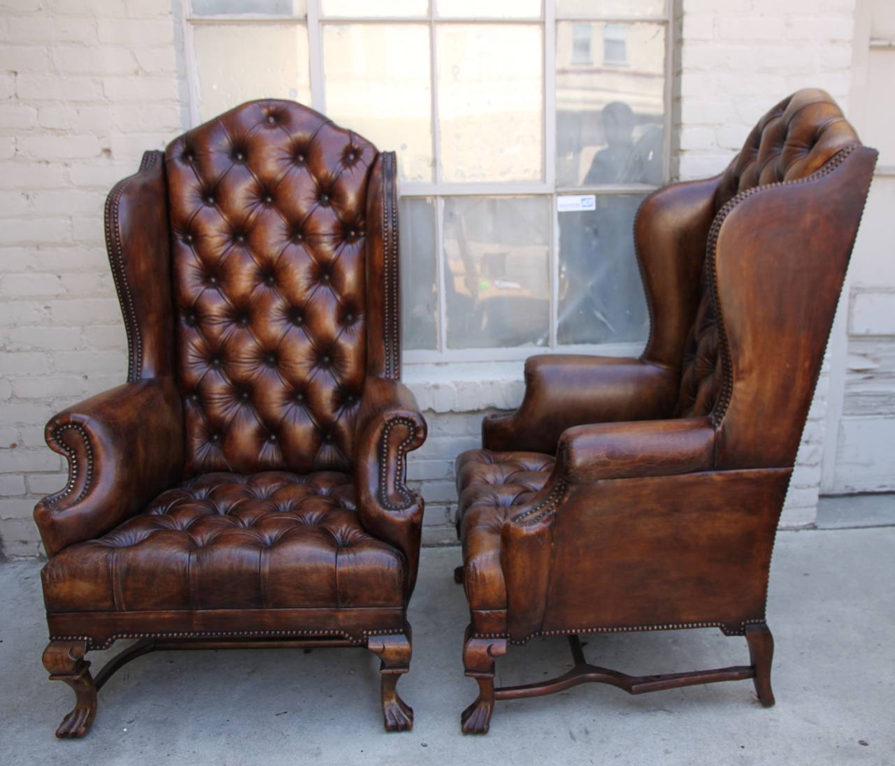 Pair of high back English Leather Tufted Armchairs with nail head trim detail.