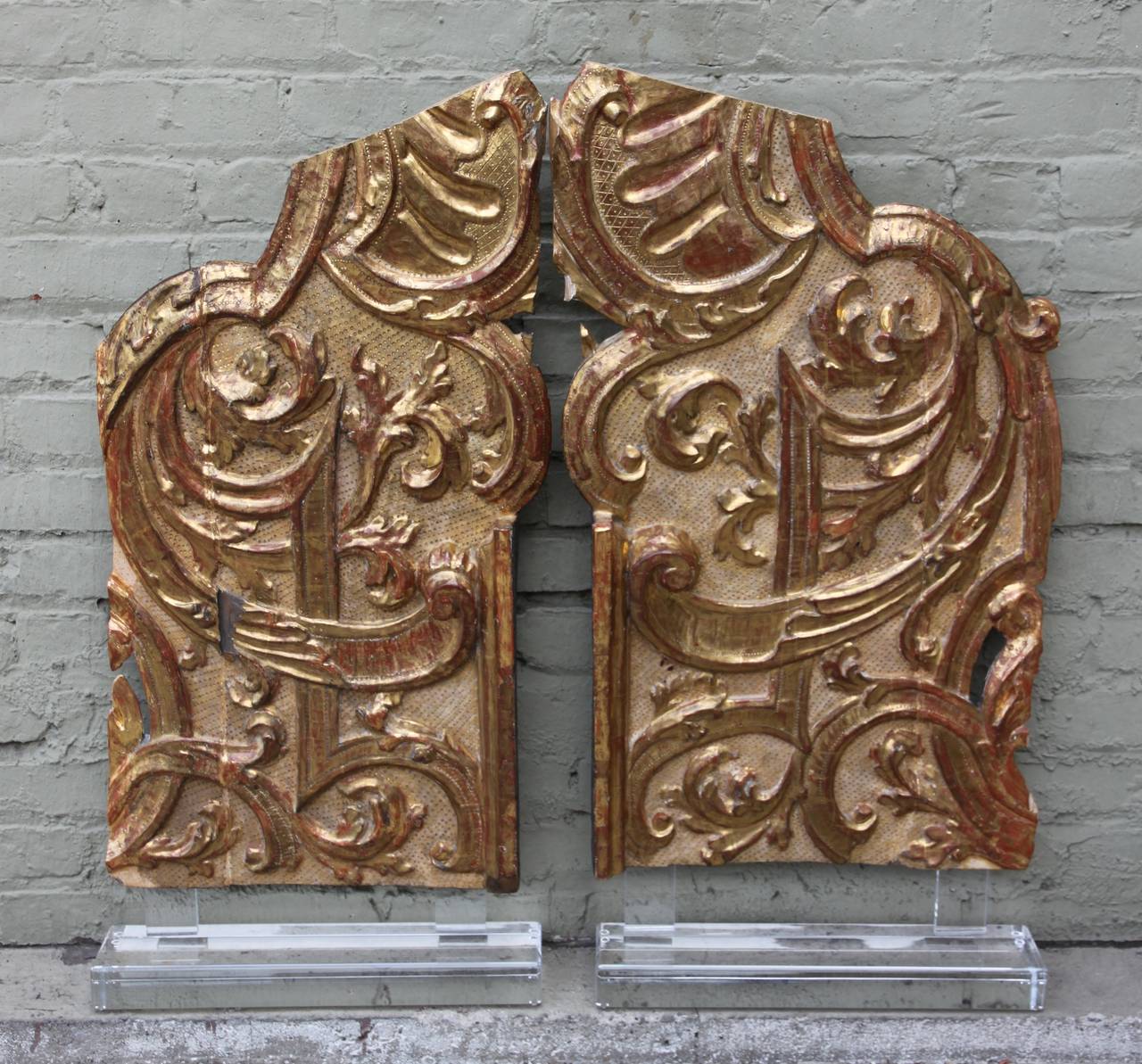 Pair of Italian monumental carved 22-karat gold leaf architectural pieces mounted on Lucite bases.