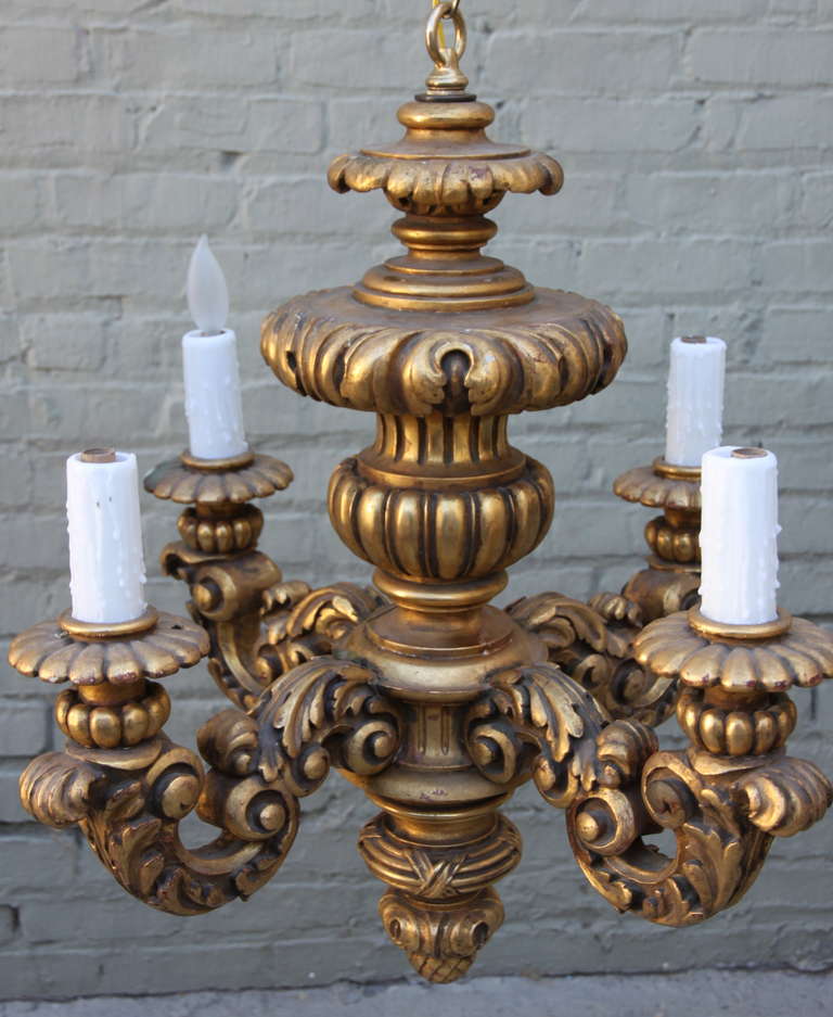 19th century four-light Italian carved giltwood chandelier. Newly wired with wax candle covers and original carved giltwood canopy.