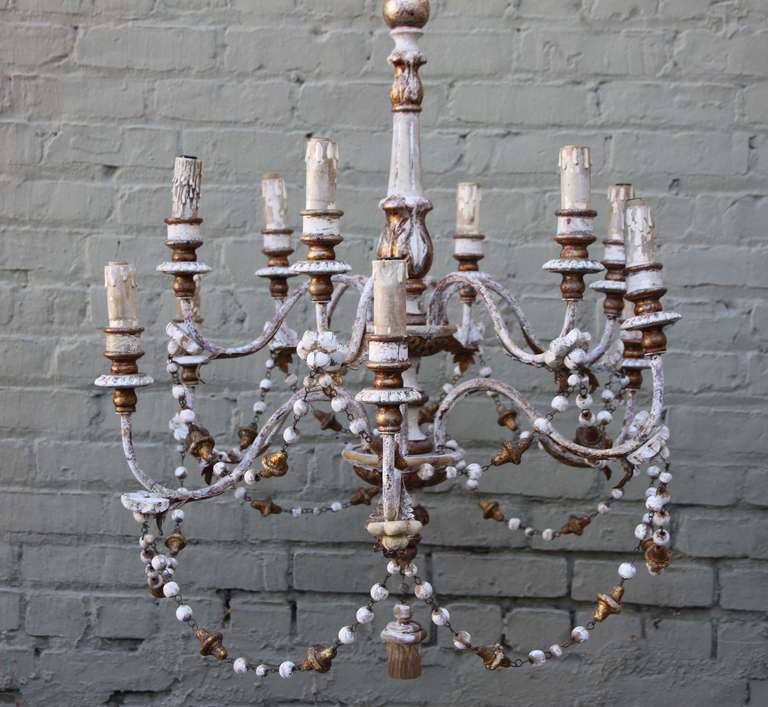 Twelve light Italian painted wood beaded and metal chandelier with original canopy.  In working condition.