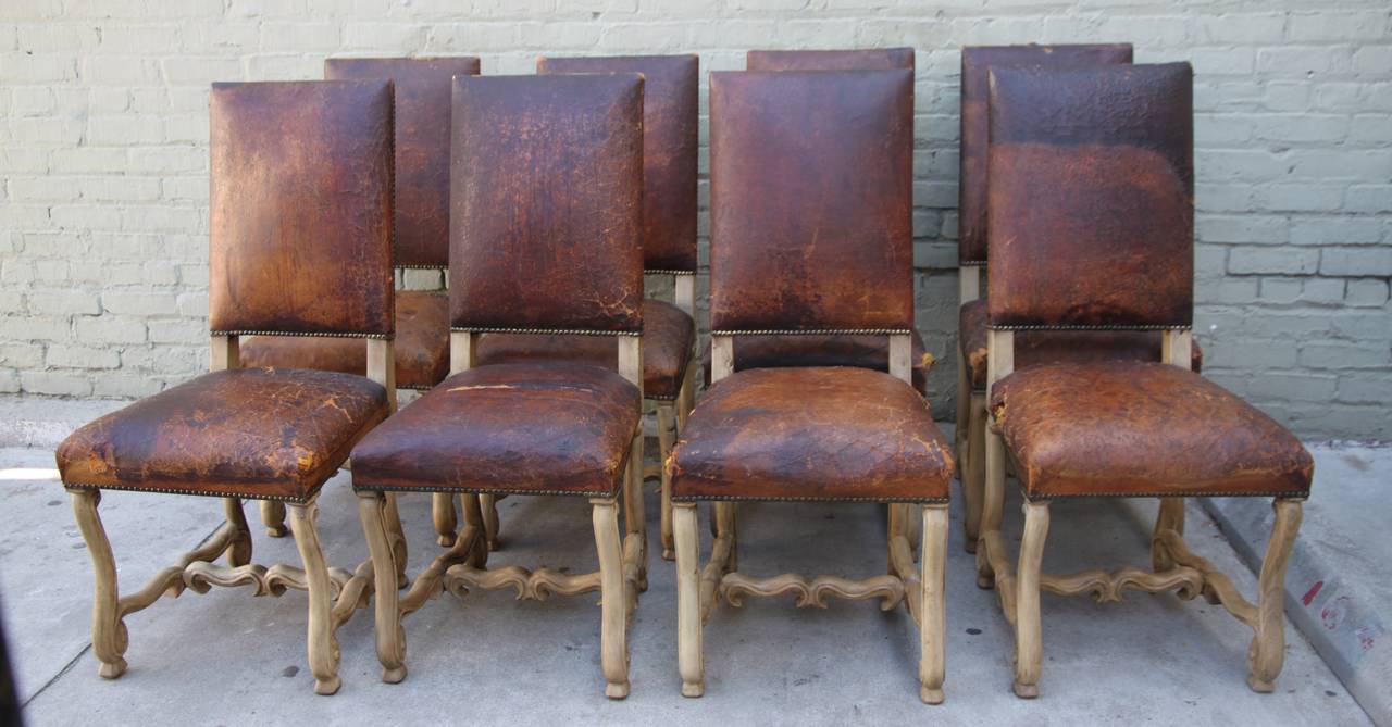 Set of eight Spanish leather dining chairs upholstered in original leather with nailhead trim detail.