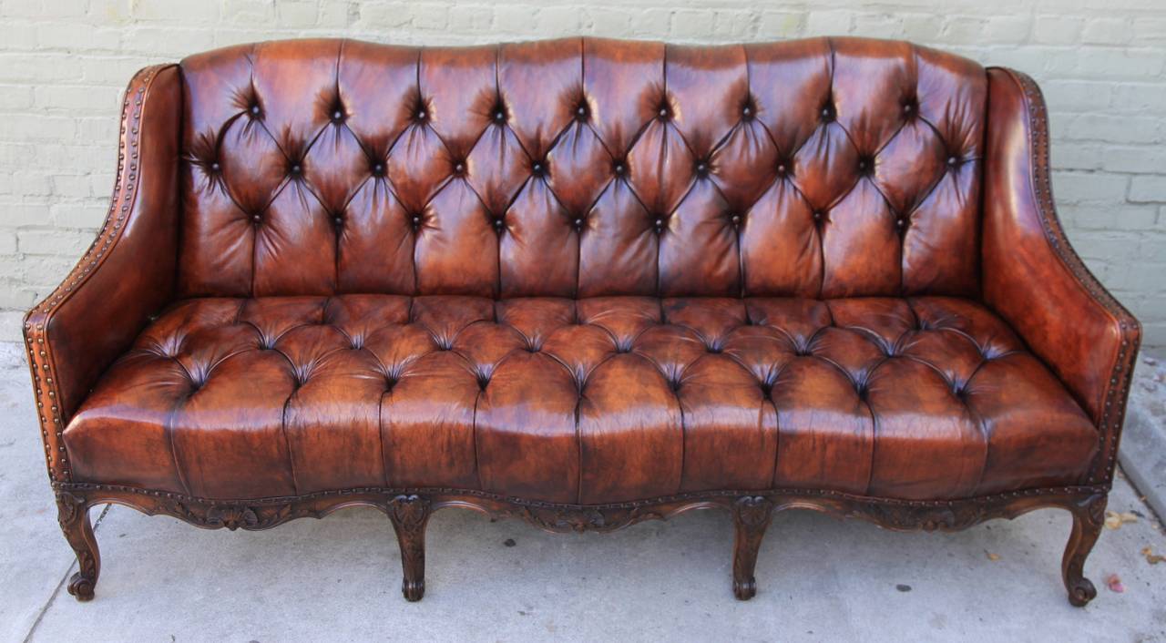 19th century French leather tufted sofa standing on eight cabriole legs with nailhead trim detail.