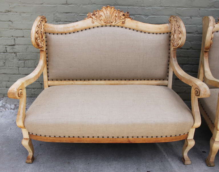 Carved French Baroque style sofa upholstered in burlap with nailhead trim detail.