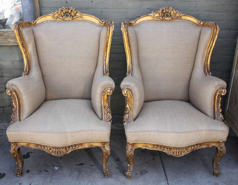 Pair of 19th century Louis XV style wood painted & parcel gilt Bergeres standing of four cabriole legs and newly upholstered in burlap upholstery with double cord detail.