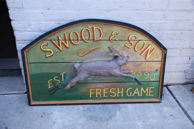 Primitive wood sign with carved rabbit stating, S. Wood & Son, est 1890, Fresh Game, in soft shades of yellow, green and grey with red highlights.