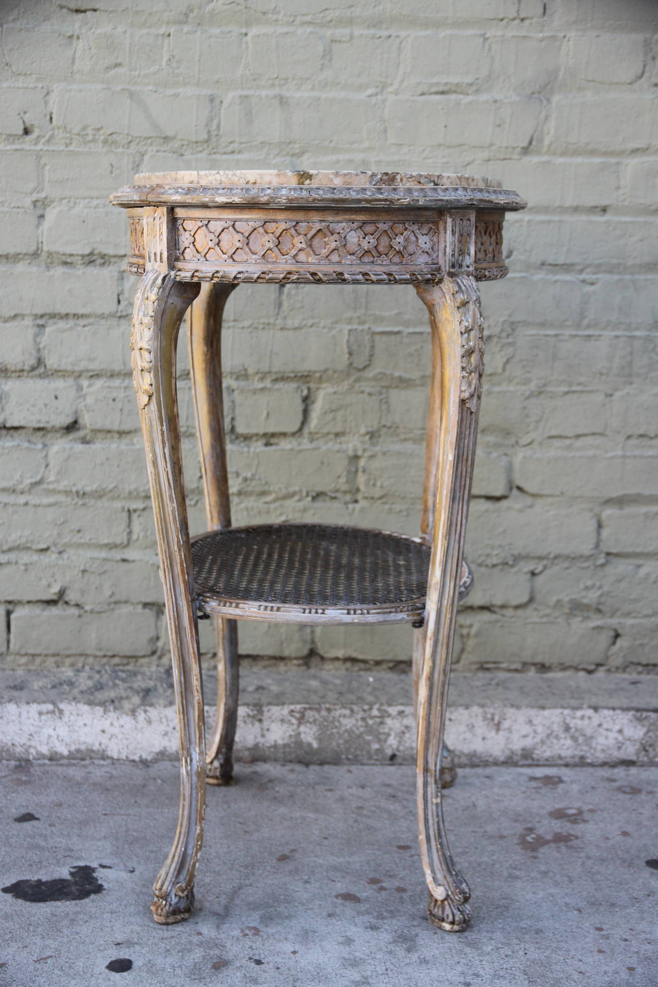 French carved painted table with cane shelf and inset marble top.