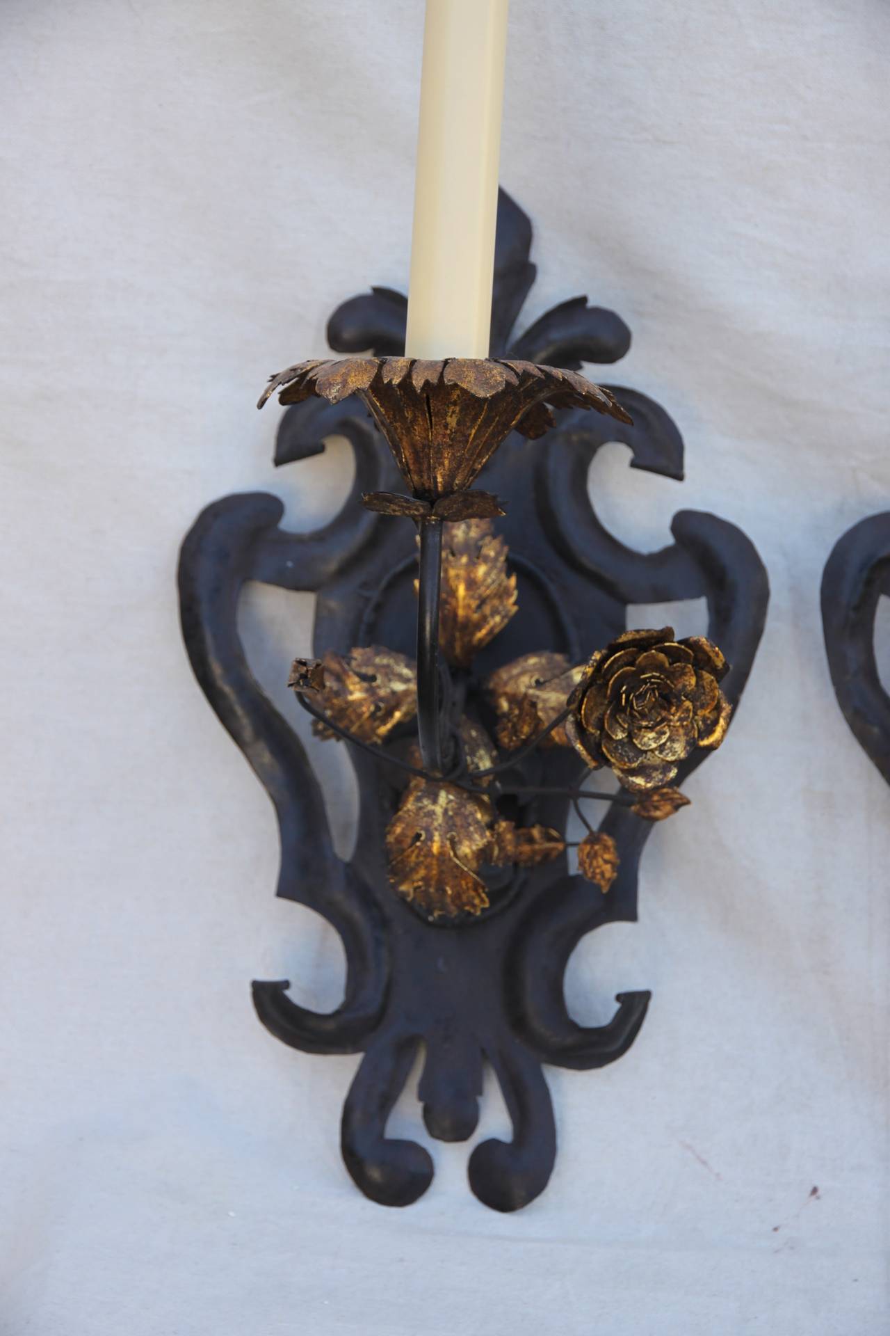 Pair of Paul Ferrante, French style, one-light wrought iron fleur-de-lys sconces with gold gilt roses. 19