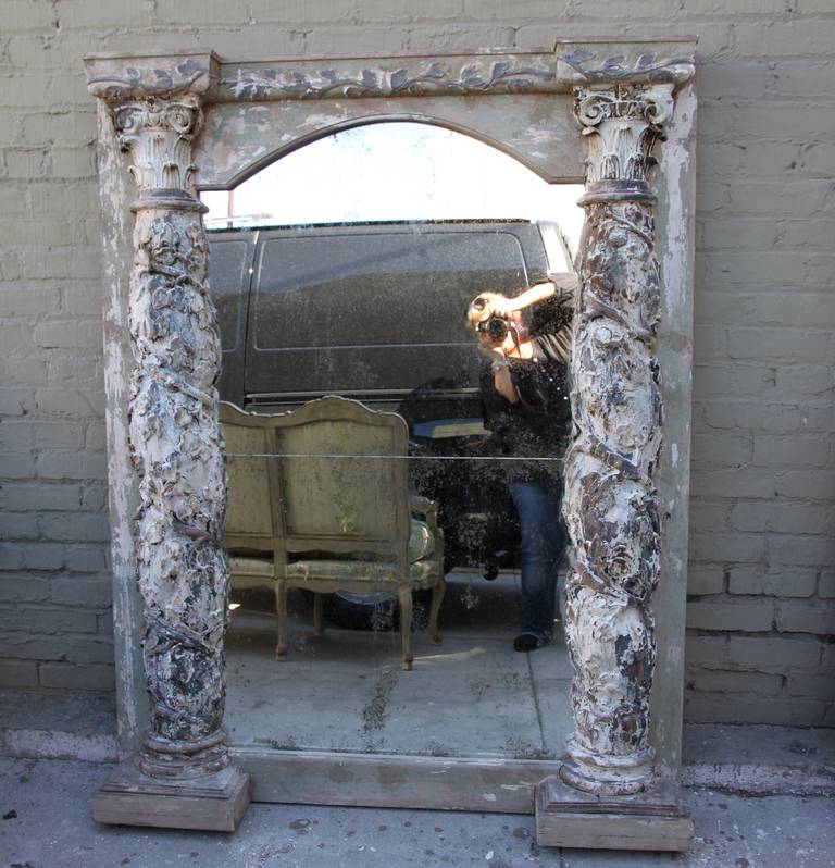 Pair of monumental painted Italian mirrors with antique Corinthian columns flanking either side of the antiqued glass.