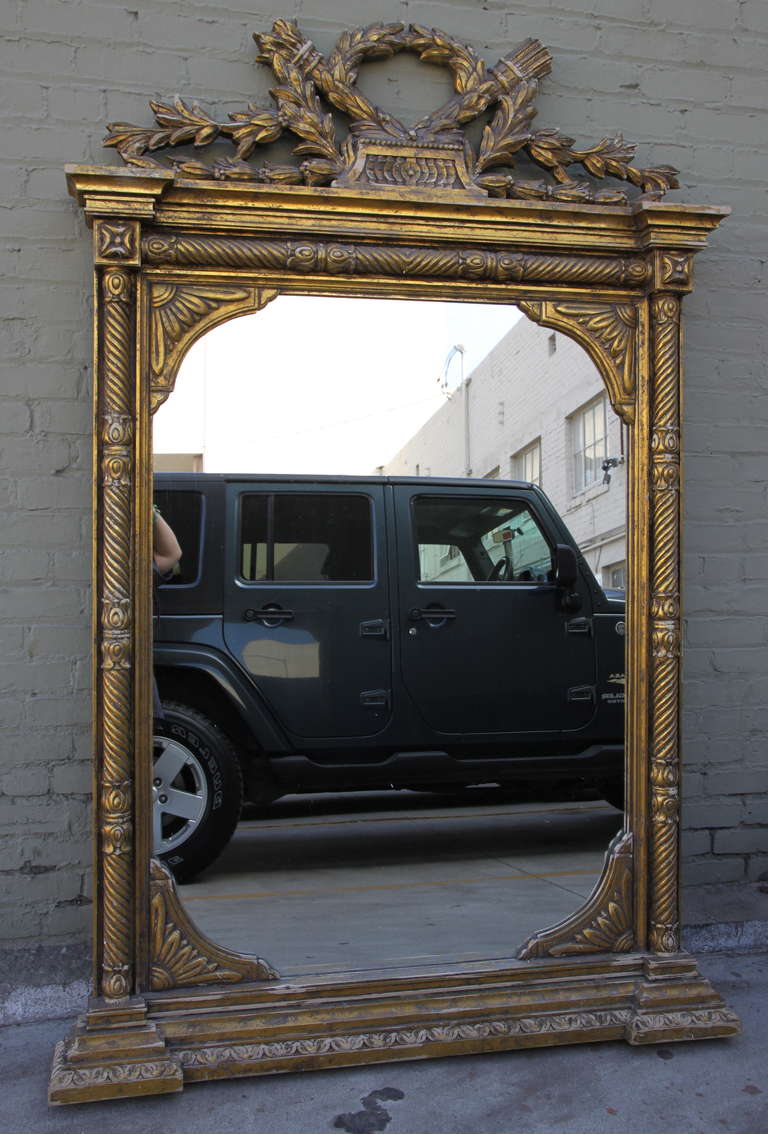 Grand scale French giltwood mirror with laurel leaf wreath.