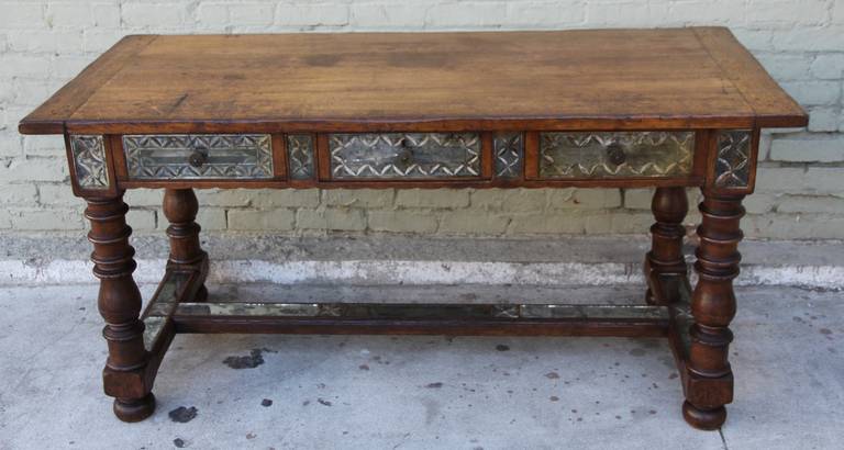 19th century Spanish walnut desk or table with three drawers. Antique mirror insets around the apron and across the stretcher of the table.