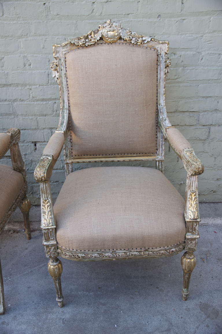 Pair of French carved painted & parcel gold gilt armchairs. Newly upholstered in burlap with self welt and nailhead trim detail.