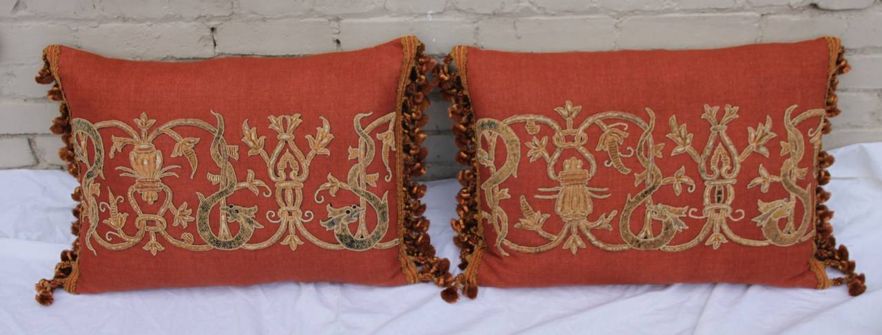 Pair of 19th century metallic appliquéd rust colored linen pillows with silk tassel fringe. Down inserts.