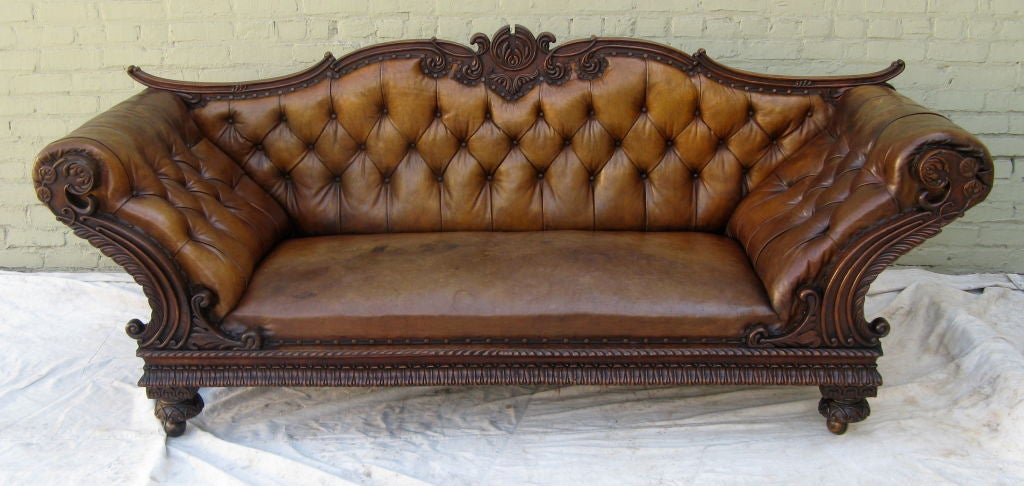 Stunning leather tufted sofa with fine carved details throughout.