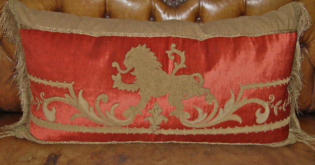 19th century embroidered red velvet lion textile on neutral raw silk background with metallic trim on both ends.