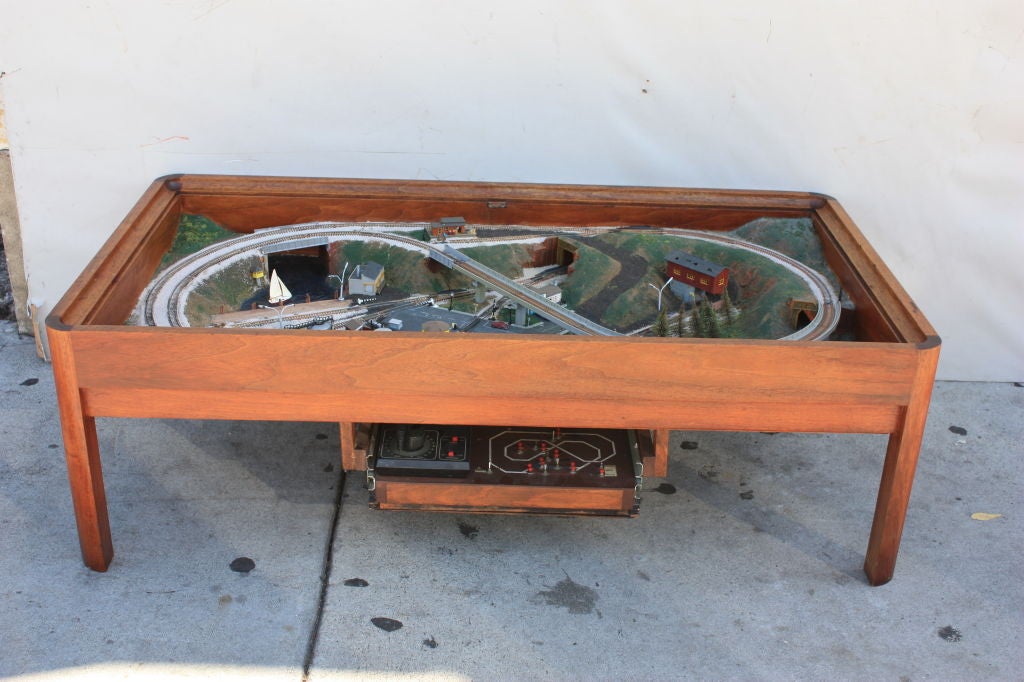 Who else is going to have one.Glass covered table with amazing train set. N gauge with 2 locomotives and two sets of tracks. Has a pond with sail boat several buildings, cars and people trestles etc. Has a pull out from under the table with