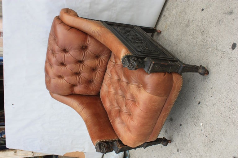 Very decorative early Victorian highly carved oak ebony finish arm chair with rams heads arms, cloven foot legs and foliate side panels.Newly upholstered in tufted distressed leather.