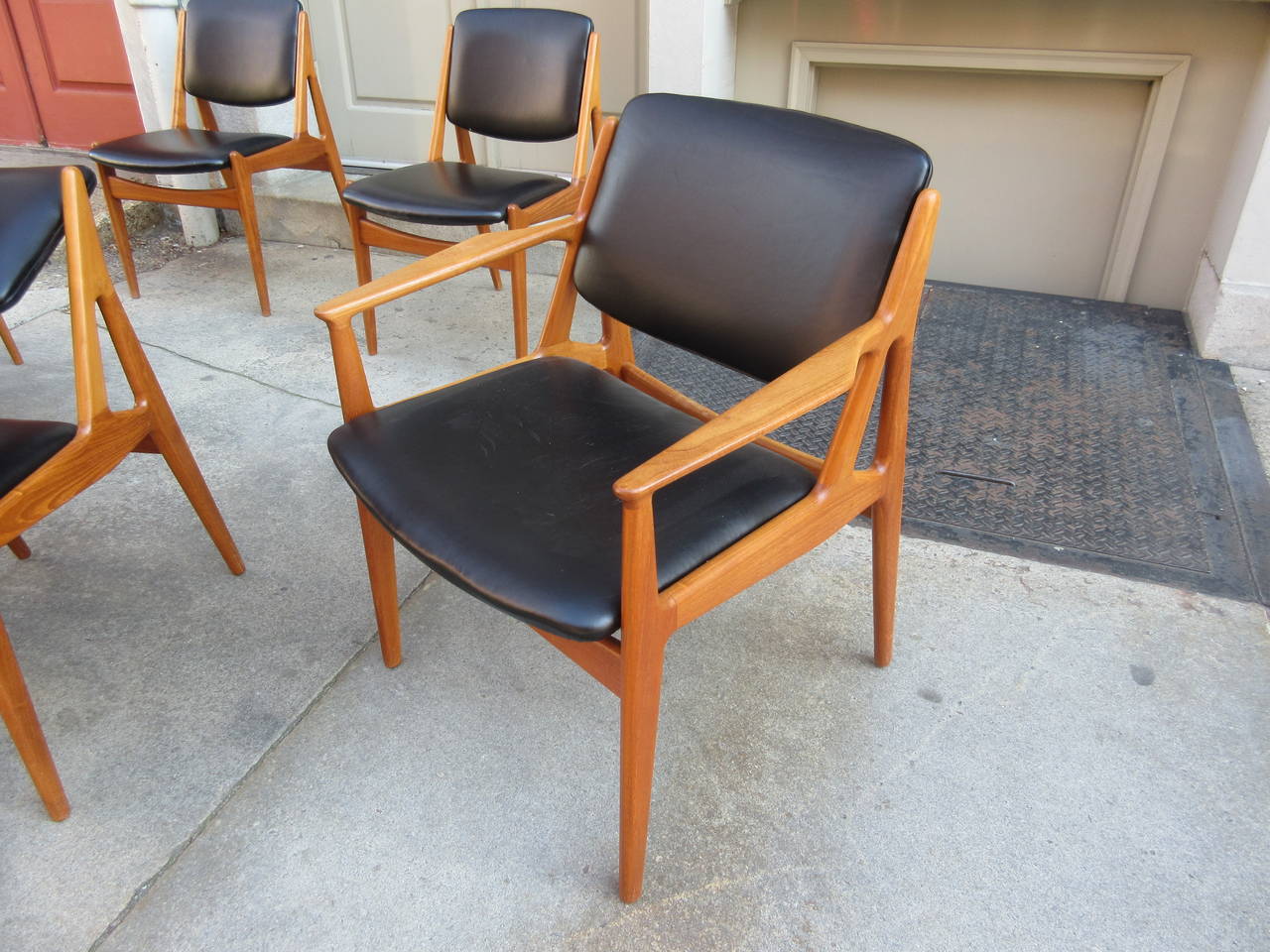 Solid teak dining chairs with pivoting backs. Leather upholstery was redone about 10 years ago. Great Vodder design that allows for total dining comfort! All chairs are very solid and straight, fine scratch marks on a few of the leather seats.
