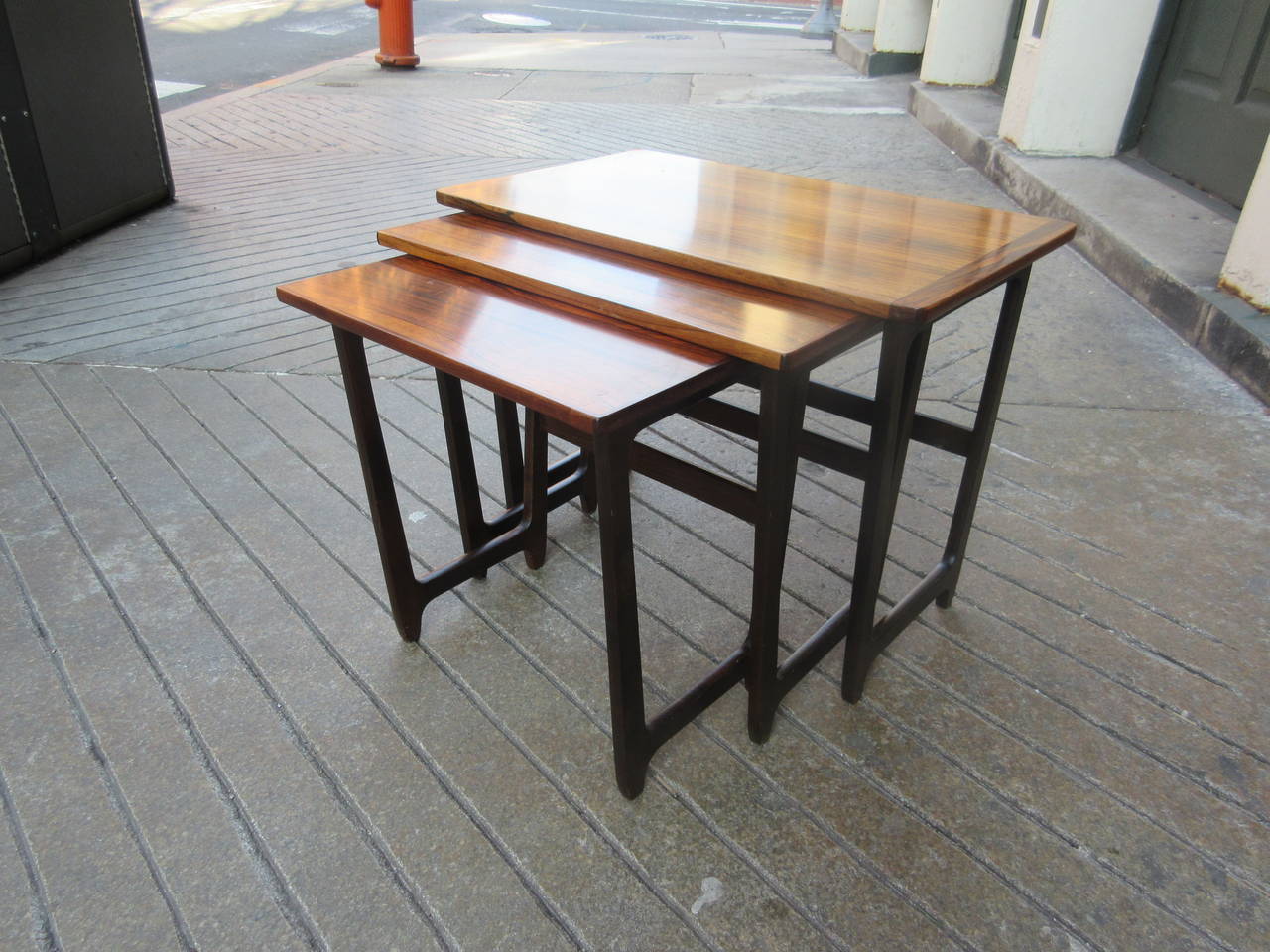 Rosewood nesting tables. Illegible ink stencil on smallest. Terribly practical and a space saver.