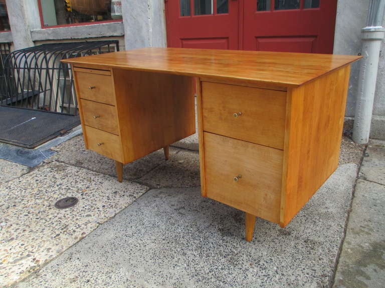 McCobb large double pedestal desk in solid birch with brass hourglass pulls. Refinished.  Has branded mark.