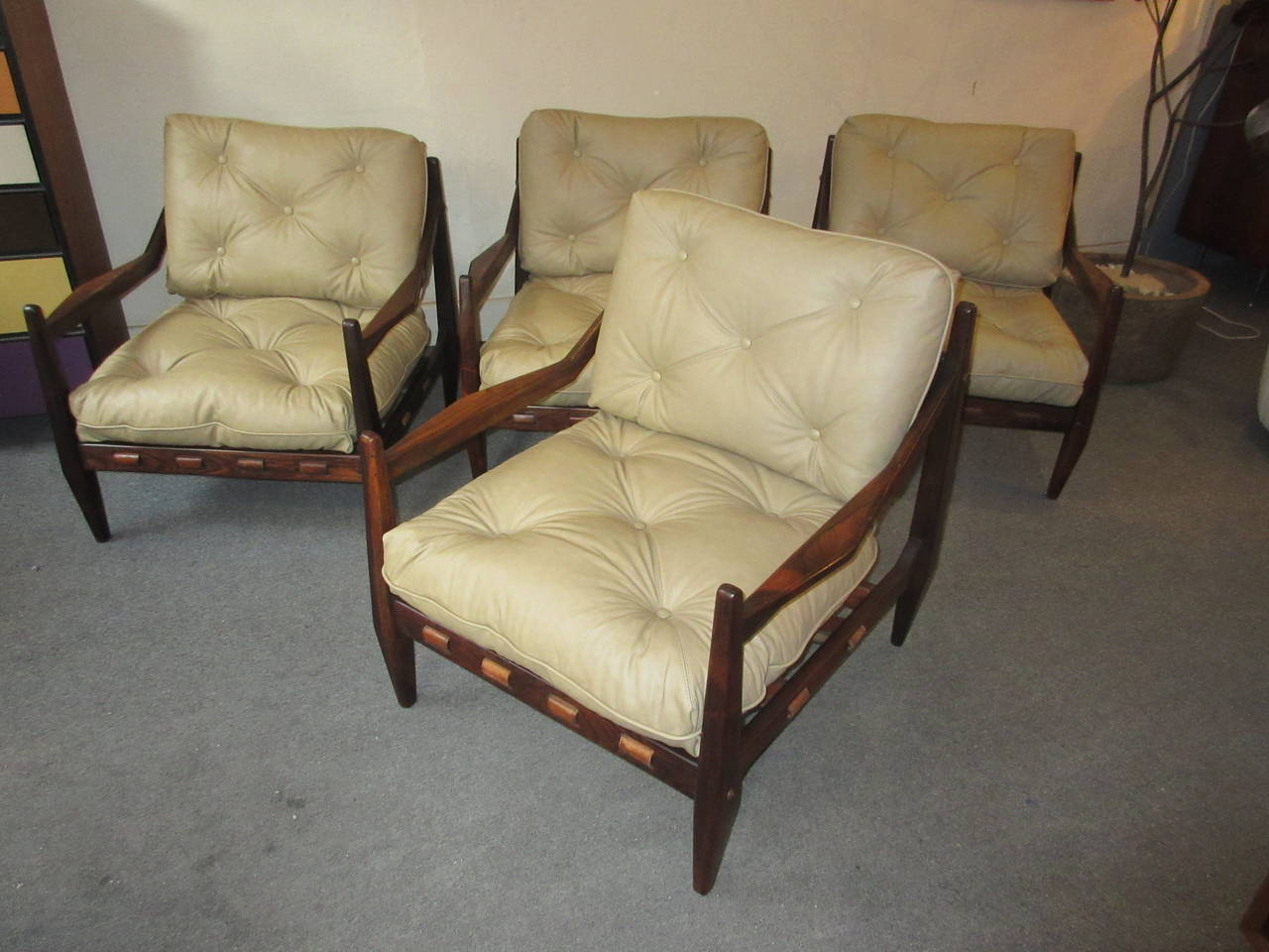 Four matching armchairs of solid jacaranda wood with new leather cushions in a very light tan done as the original in double stitched seams. Legs and arms are beautifully tapered and sculpted.