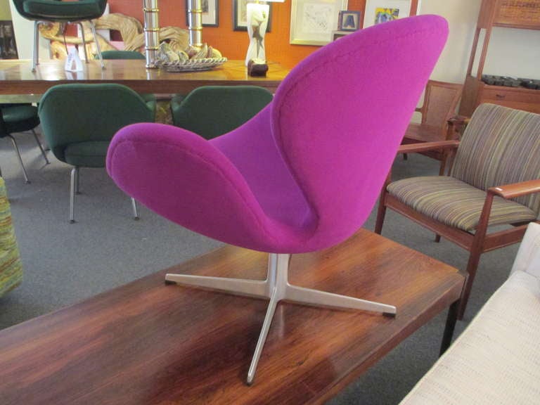 a 1960's edition of this swivel chair freshly reupholstered in a vibrant purple. Bought from original owner who purchased the chair in the early 1960's. Second chair available in need of reupholstering.  Still in its original purple hopsack fabric. 