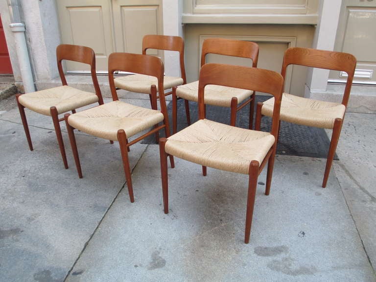 Completely refinished and re-rushed set of six solid teak Danish dining chairs by Neils Moeller. Matching 47 inch in diameter Moeller round teak dining table also available including two leaves. Pictured