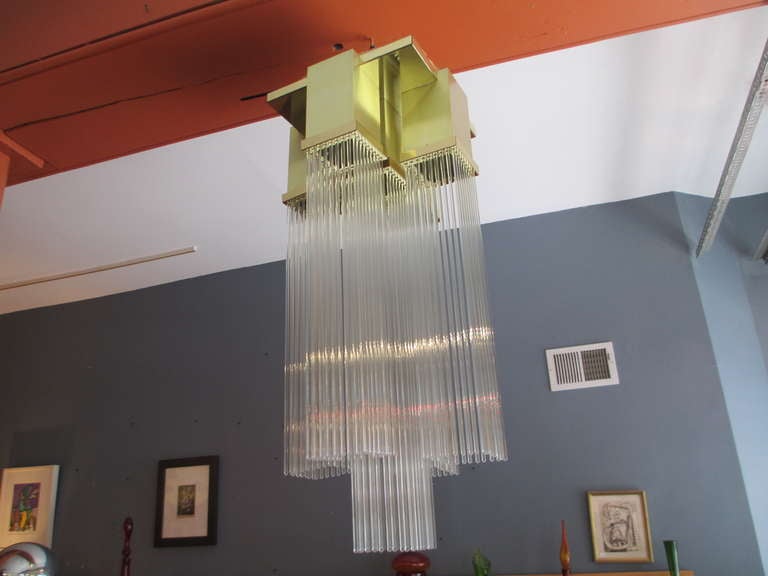 Large and impressive flush to ceiling mounted chandelier of brass cubes with suspended glass rods.  Brass mounting has a vaguely mission design but from the 1970's.  Three rods are missing and  we have spaced them on the inner rim and it is very