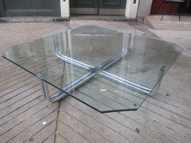 Over sized glass topped coffee table with chromed steel base.  Base retains portion of Cassina label. Glass has ground out grooves for plastic capped supports to fit into.