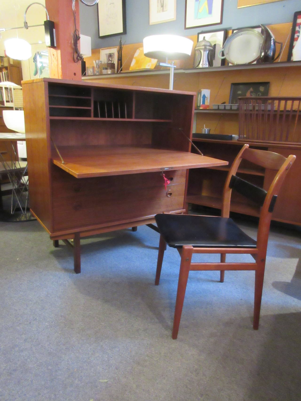Teak drop-front desk with one large drawer and two smaller. Drop-front reveals cubbies and ample work surface. Refinished and ready to go! DUX chair is included with desk.