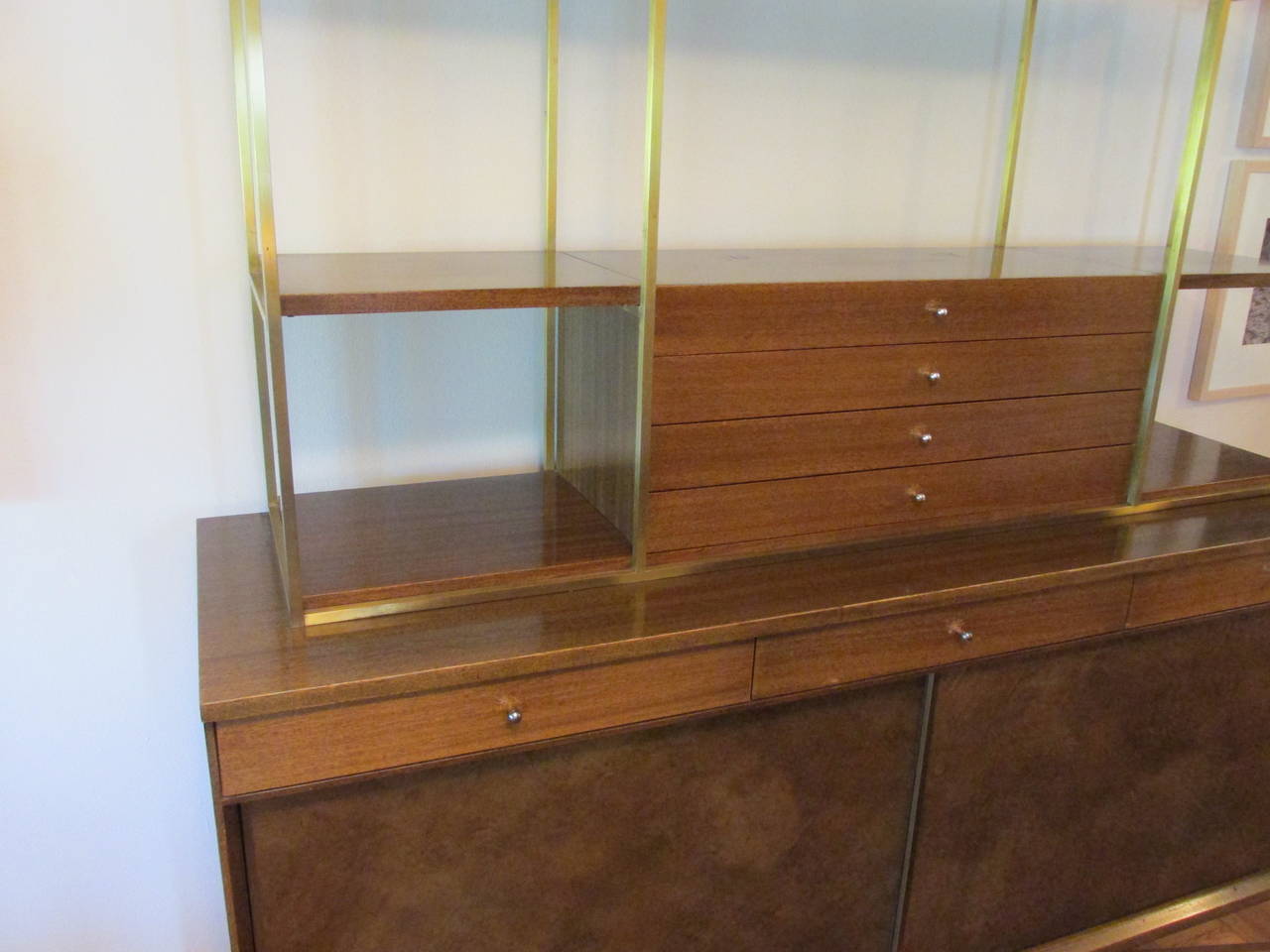 Large walnut and brass credenza with removable top. Legs are joined by an X-shaped brass stretcher. Bought from original owner who purchased it in 1954. Top drawer on bottom part has metal Calvin tag.