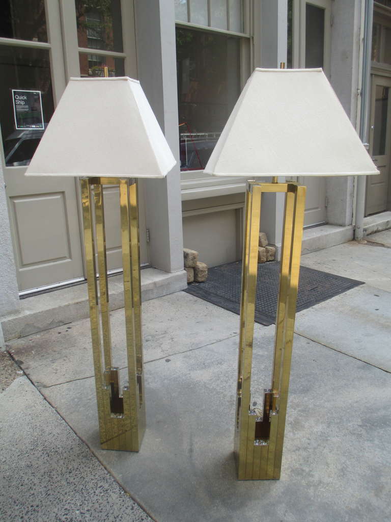 Pair of 1970s floor lamps in a composite of brass and chrome squares and rectangles.  Four equal supports rise to hold square cloth shades. Each lamp has a three way switch.
