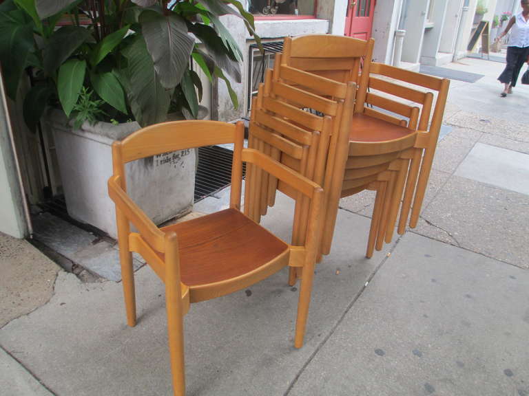 Set of six large arm chair that stack of solid birch with mahogany veneer or plywood seat.  Each chair retains a remnant of a lable with a 15 East 53rd St. NYC address.  There is a zip code so these chairs are  or are newer than 1964.  Exceptionally