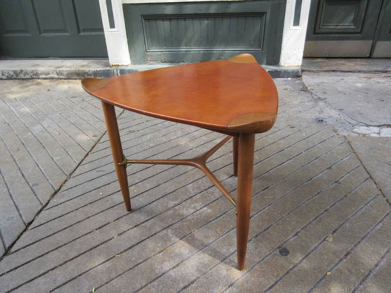 Light walnut Henredon Triangular leather covered Table with brass stretcher. Corners turn up to reveal walnut while entire center area is leather.