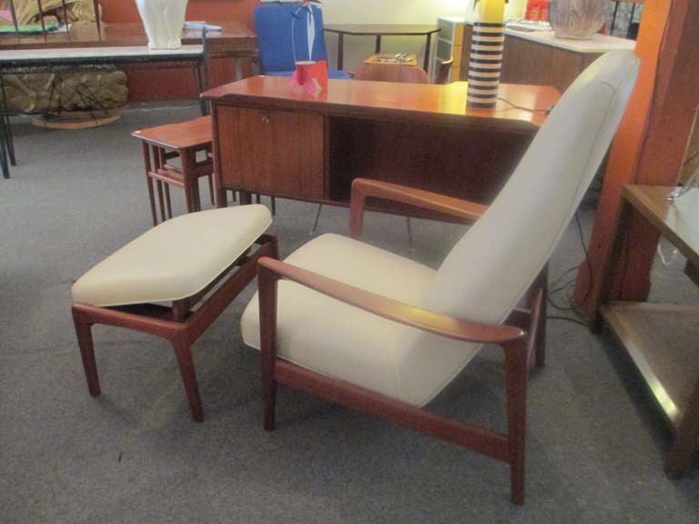 Large leather chair and ottoman by Swedish maker Dux.  Chair has springing rocker and one side of  ottoman can raised and lowered to provide optimal comfort,  frame is solid teak and leather is newly redone in a cream.