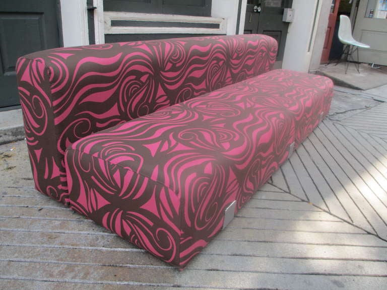 1960's mod sofa in Psychedelic fabric.  Two long bolster cushions are held in place by three stainless steel brackets.  This low slung sofa then rests on two sled like runners.
