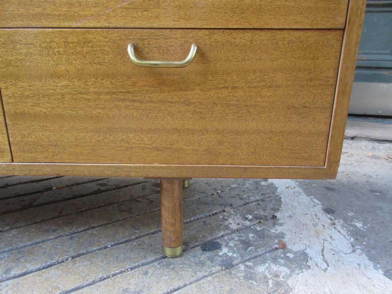 Bleached mahogany dresser with brass accents and capped legs. Retains original label and completely original finish.