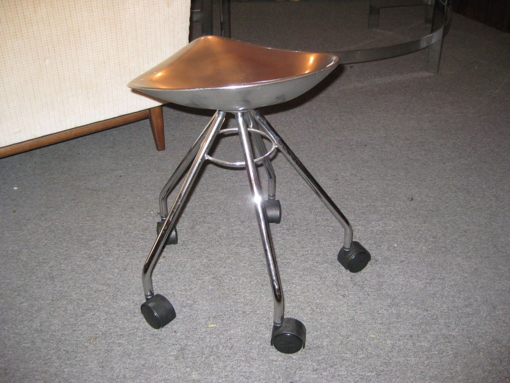 Cast aluminum seat on five steel legs with casters.  Designer and name of stood cast in metal
