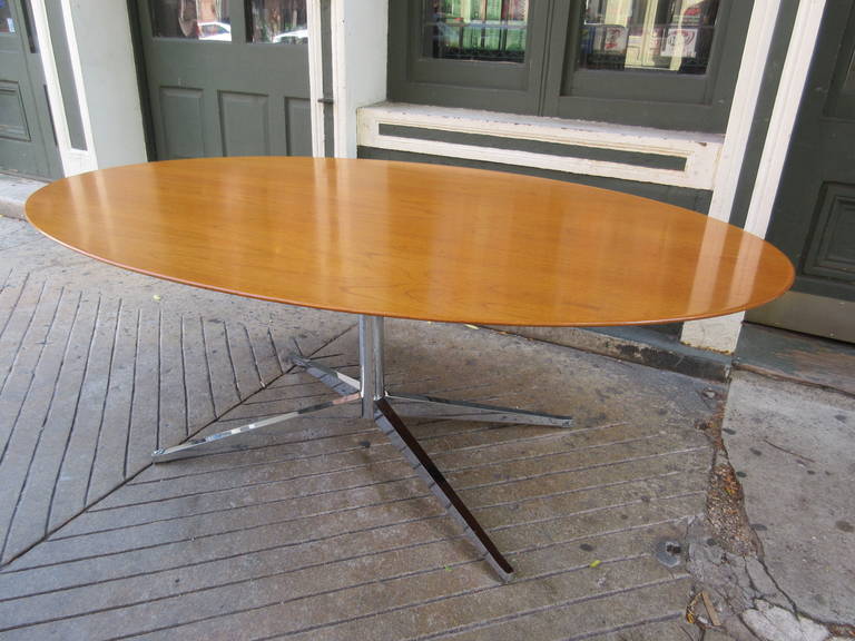 Gracious oval table on center steel post with splayed steel legs.   This table is in a no longer available pear wood.
