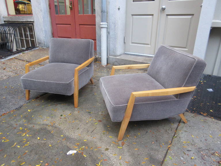 Pair of open-arm lounge chairs in the manner of Paul Laszlo. Covered in a gray mohair, solid maple or birch arms.