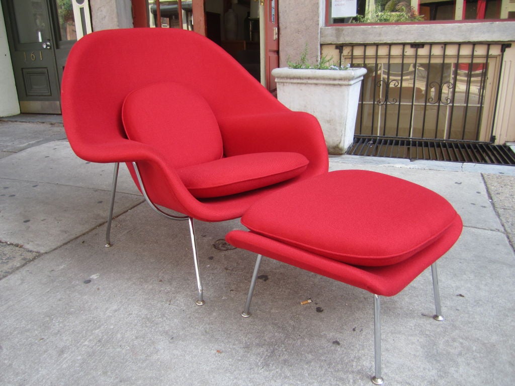 Newer edition(1990's) of Eero Saarinen's iconic Womb chair and ottoman freshly redone in beautiful red fabric on chrome frame with moveble pad feet