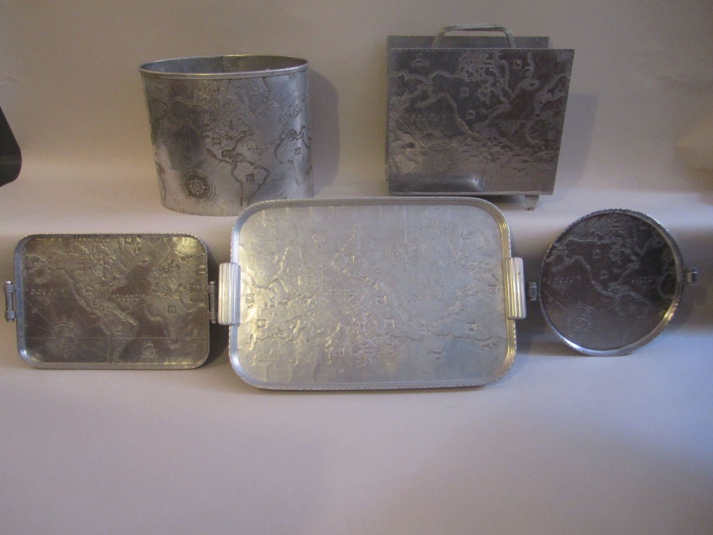 Arthur Armours most famous Art Deco design of the world Map on serving trays, magazine rack and waste paper basket.  Flat pieces are incised with Arthur Armour logo.  Will sell pieces separately