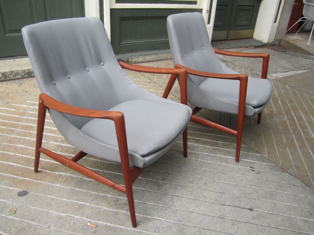 Pair of solid teak arm chairs with loose seat cushion and barrel back