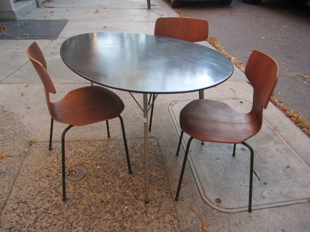 Rare egg shaped table painted black with three steel legs and rubber and metal glides.