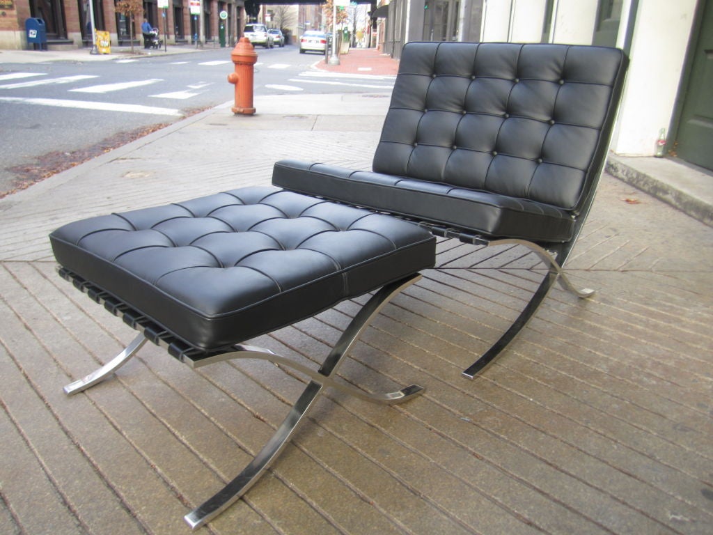 Stainless steel framed barcelona chair and ottoman with black leather cushions