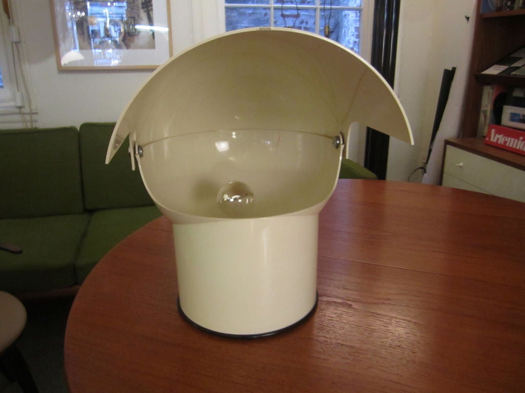 Plastik-Schreibtischlampe  mit schwenkbarem Schirm auf einem festen Sockel.  Hersteller- und Designerinformationen im Kunststoffsockel eingegossen.