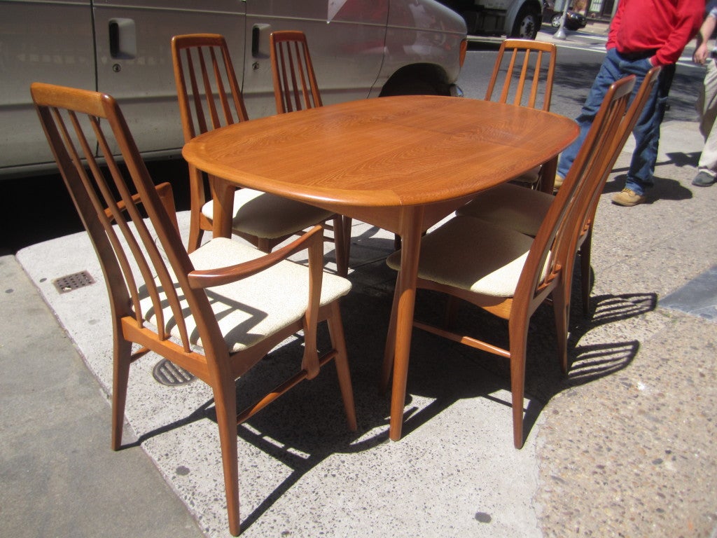 Completely refinished teak dining room table and six chairs with bifold self-storing leaf. Chairs have been recovered in a celery colored rough weave fabric.  Chairs are solid teak and table is solid and teak veneer on solid wood. Table is 62.5