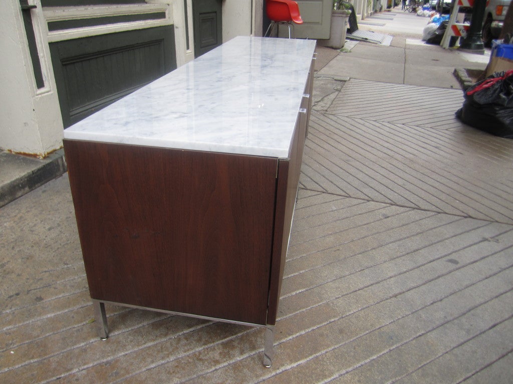Steelcase copy of a Florence Knoll credenza with four doors revealing an adjustable shelf in each opening.  Marble top has been replaced.  Base is chrome plated steel