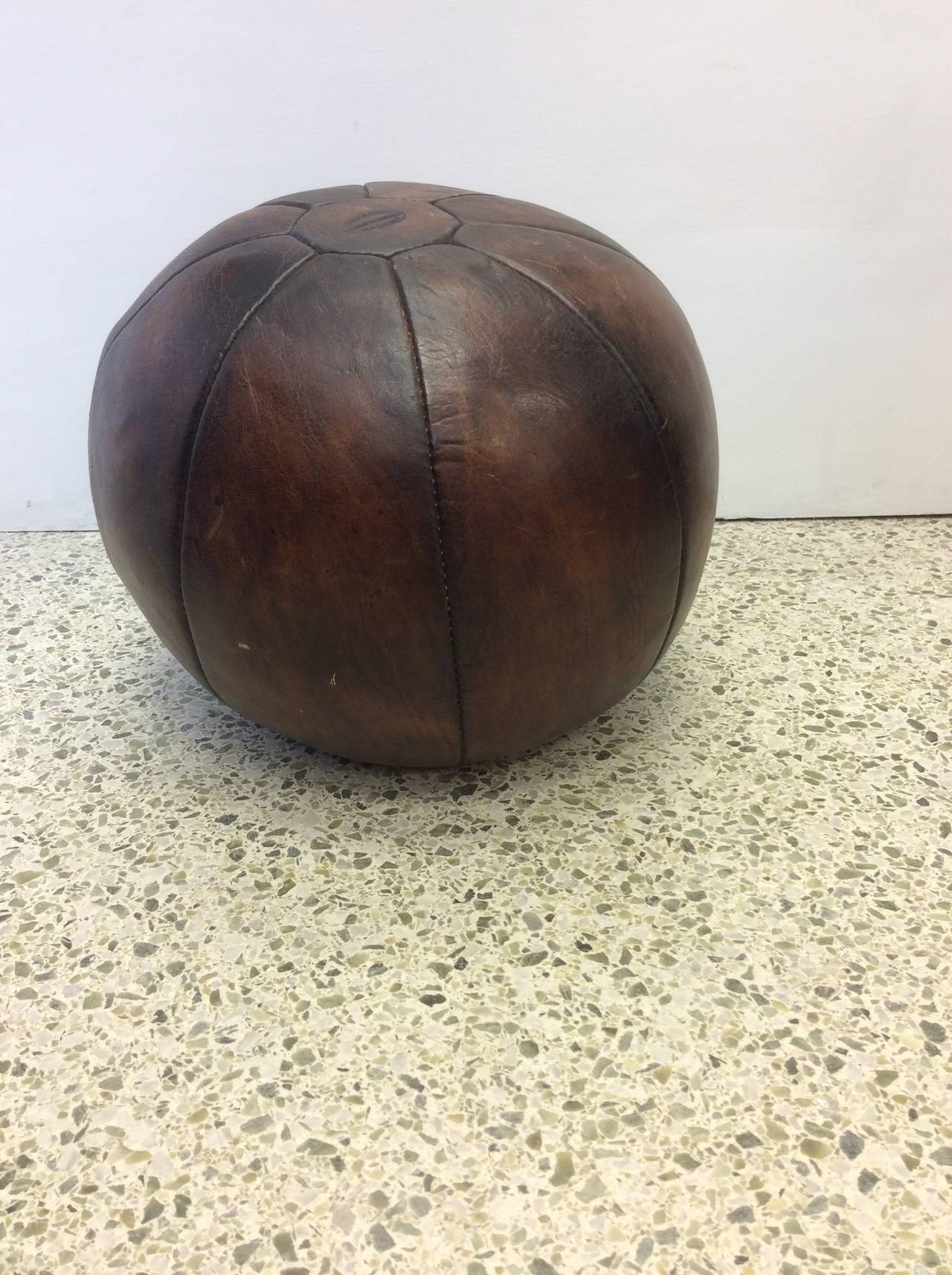 Original patinated leather medicine ball with a branded manufacturers mark.