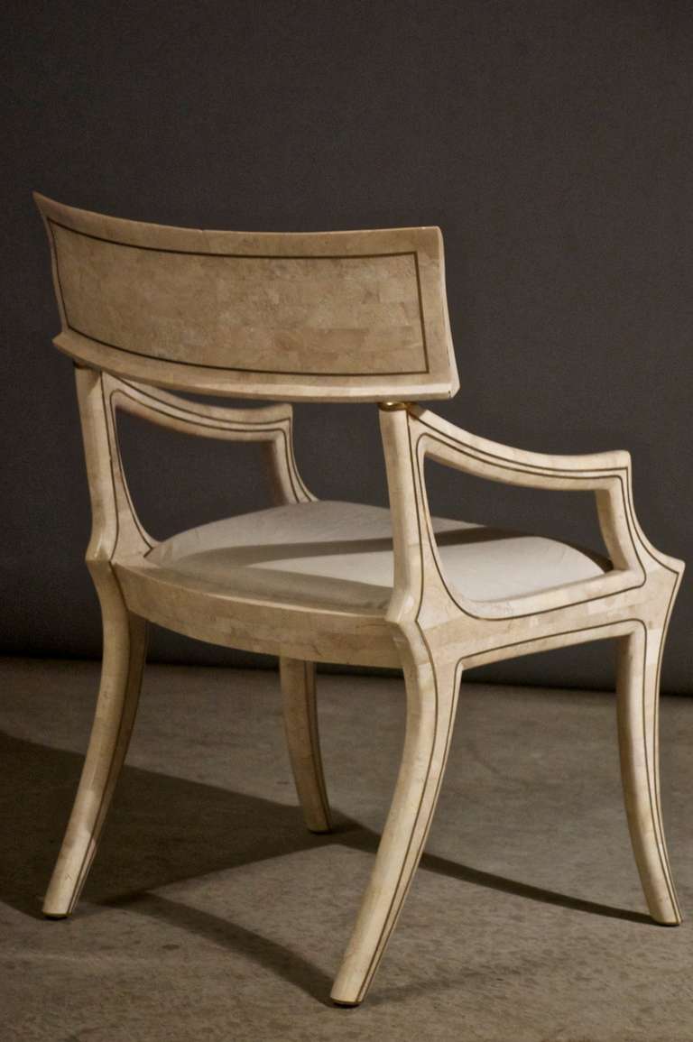 Fossil stone armchair with brass inlays.